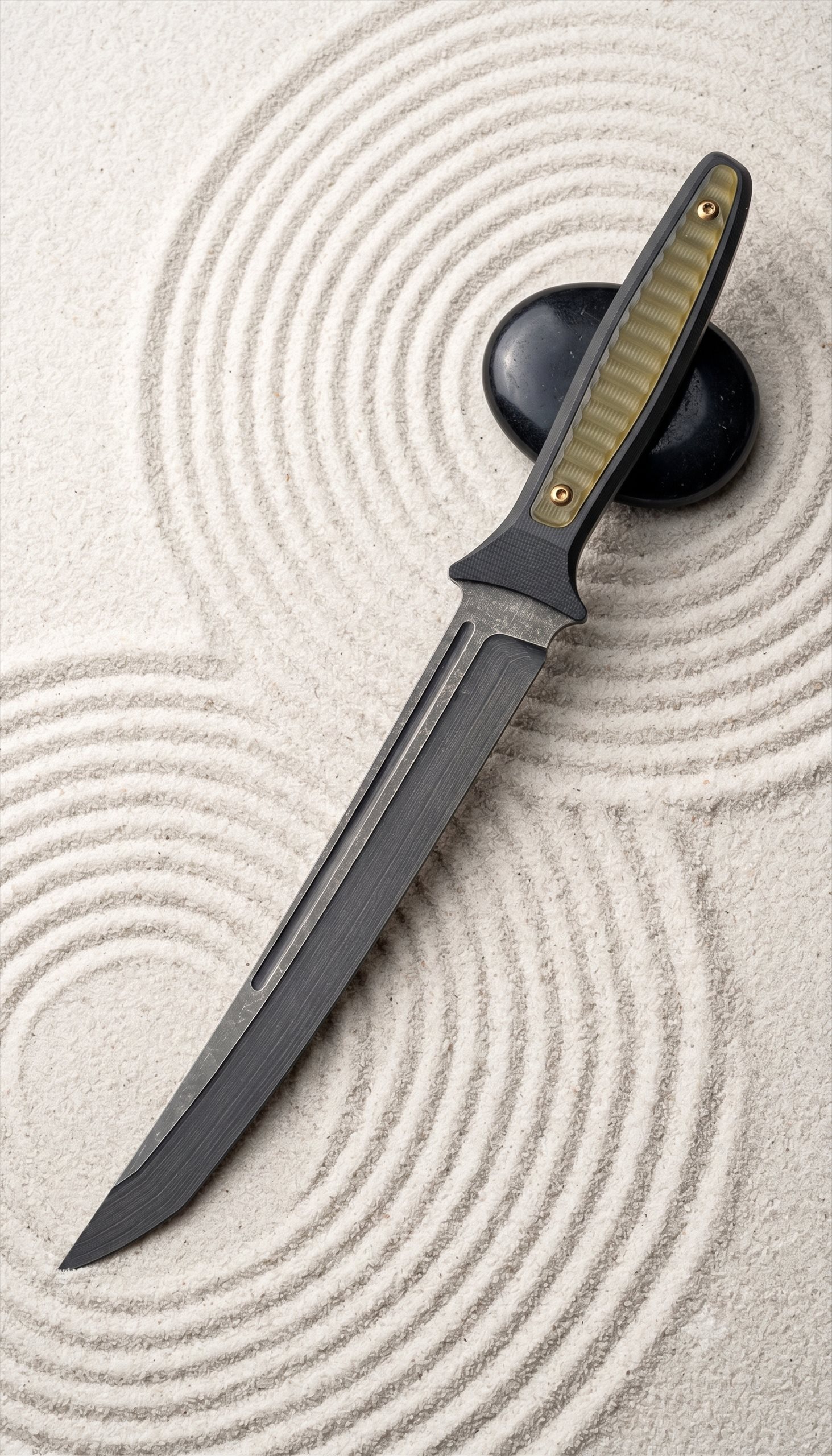 Ronin Tanto Dolch mit oliv-schwarzem Griff im Zen-Sandgarten mit schwarzen Steinen