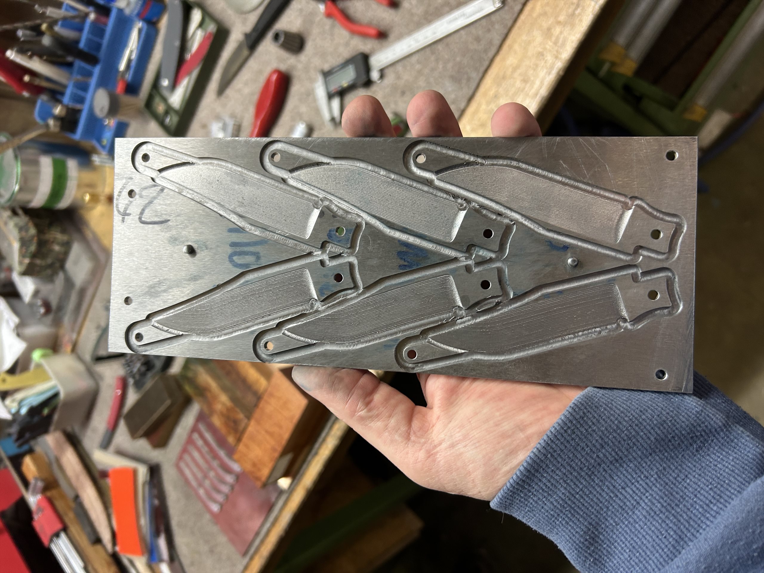 Hand hält einen frisch gefrästen Messer-Rohling in der Werkstatt von MK-Messer